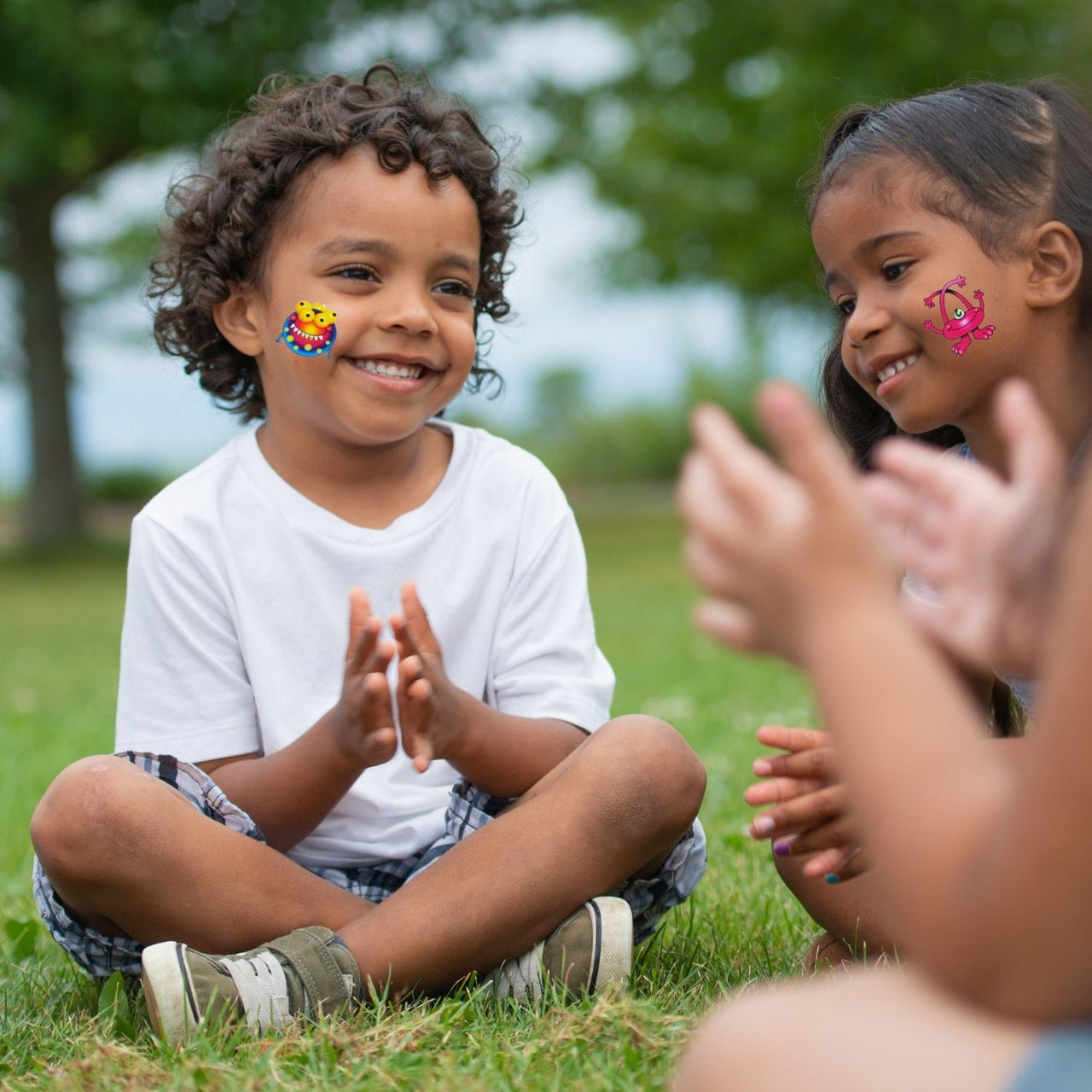 children outside wearing washable cute monster tattoos