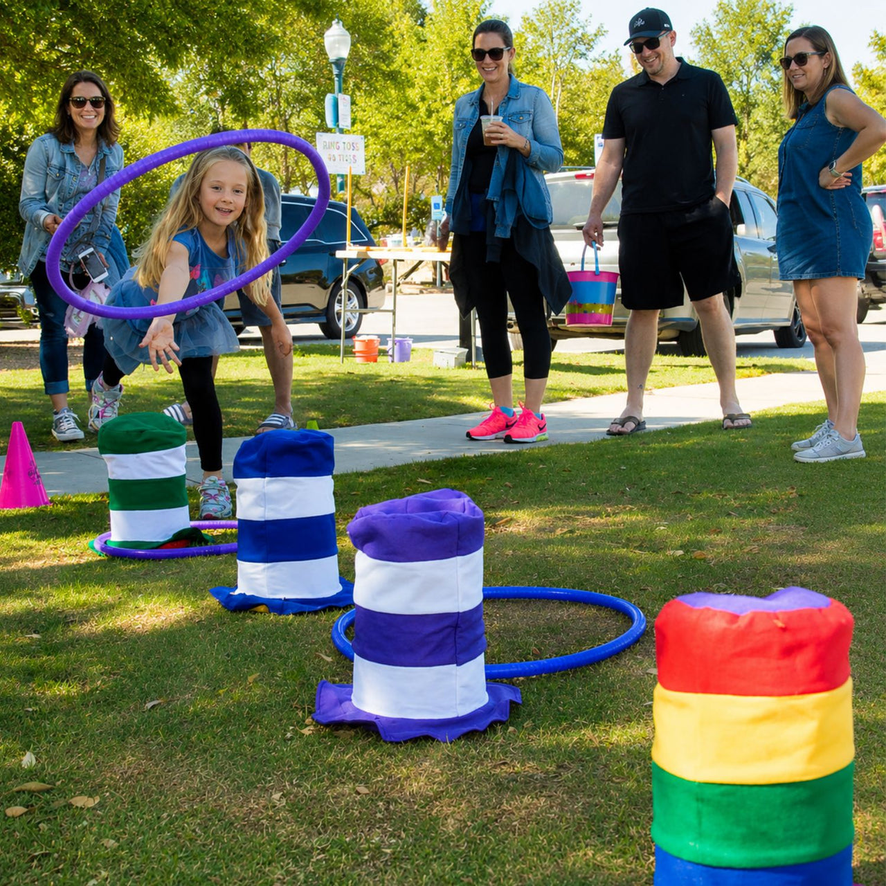 girl playing carnival game using stovepipe hats