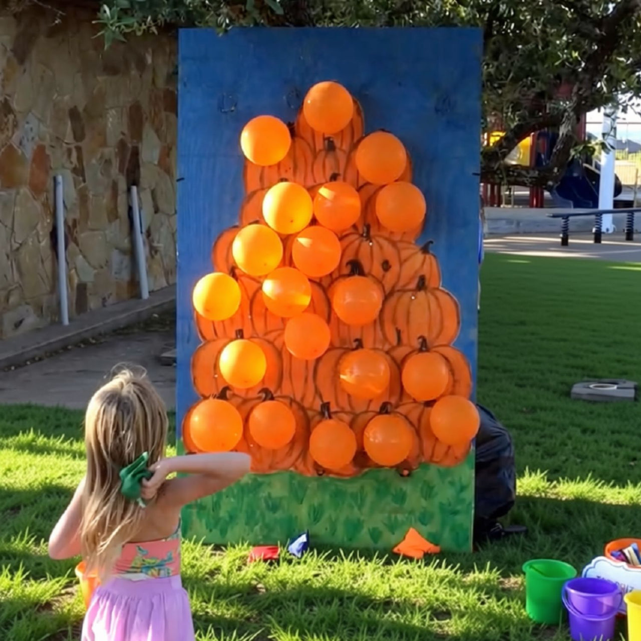 girl playing fall festival balloon pop game