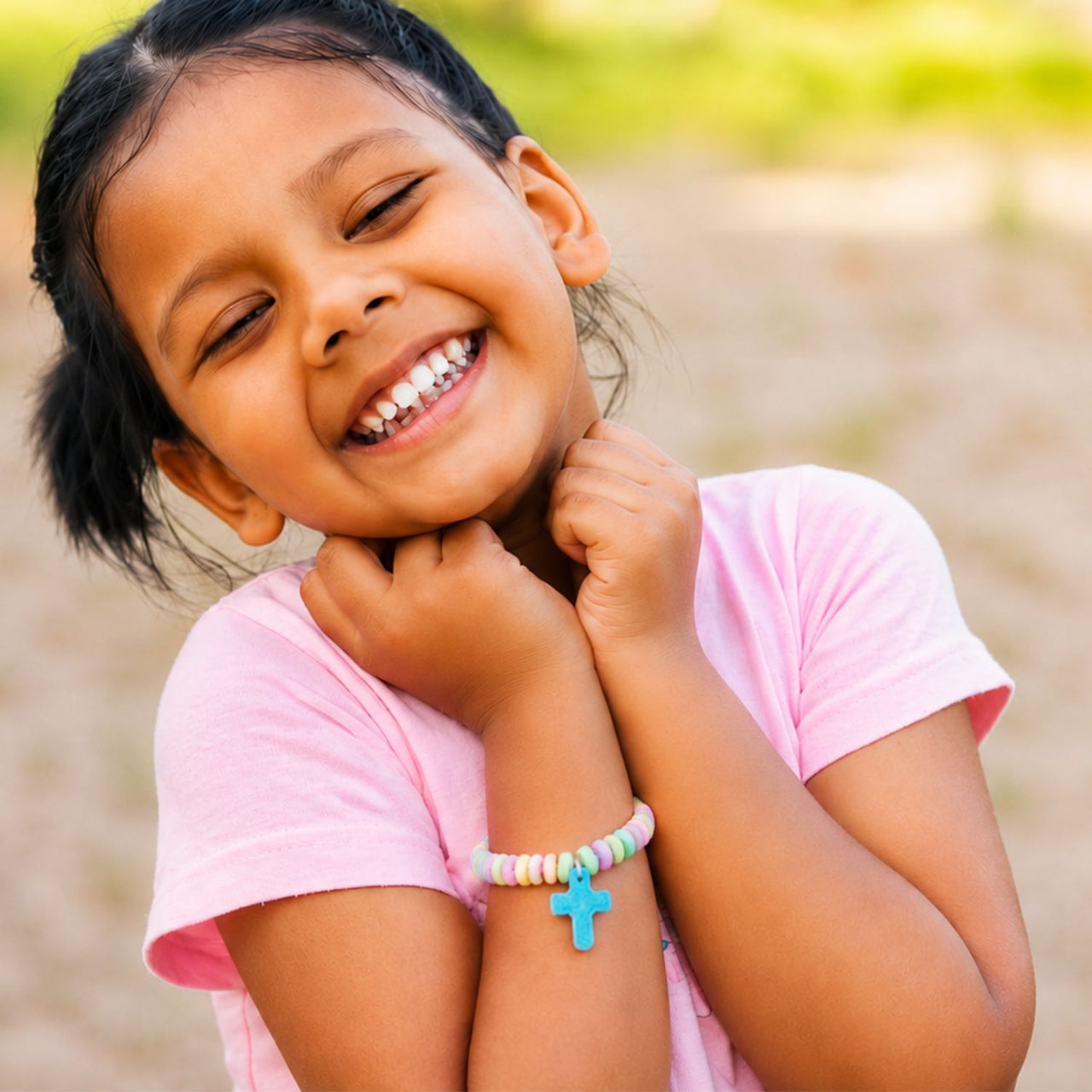 girl smiling wearing cross candy religious bracelet 