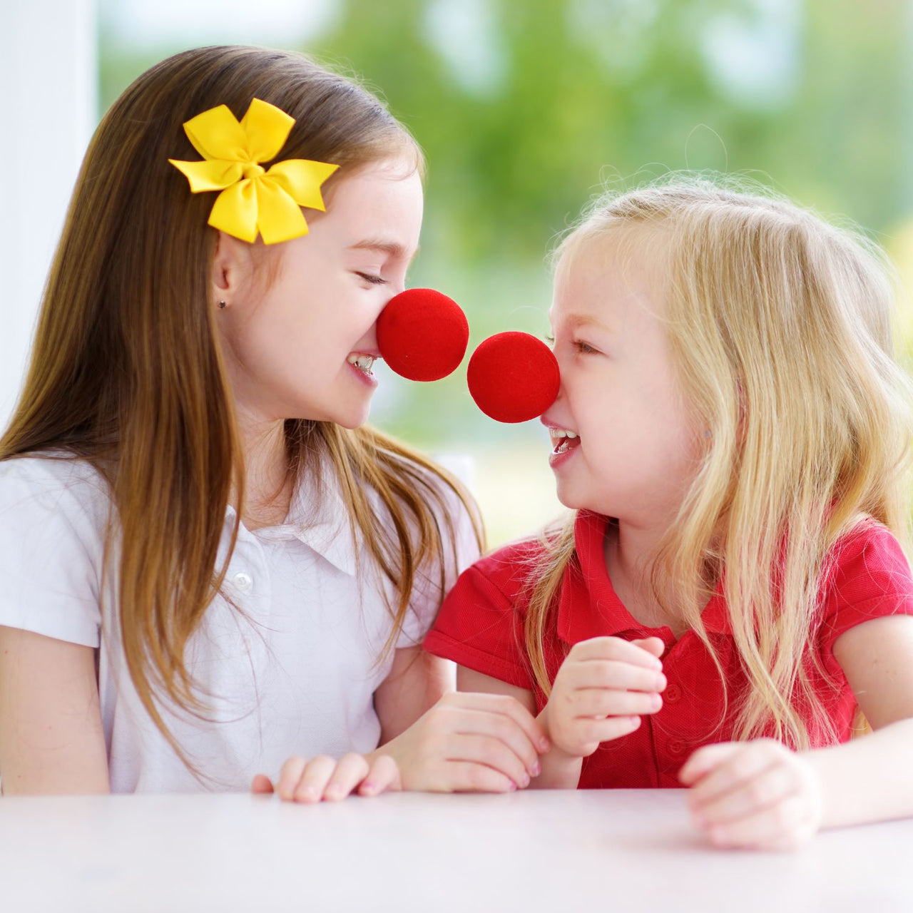 girls with clown noses laughing