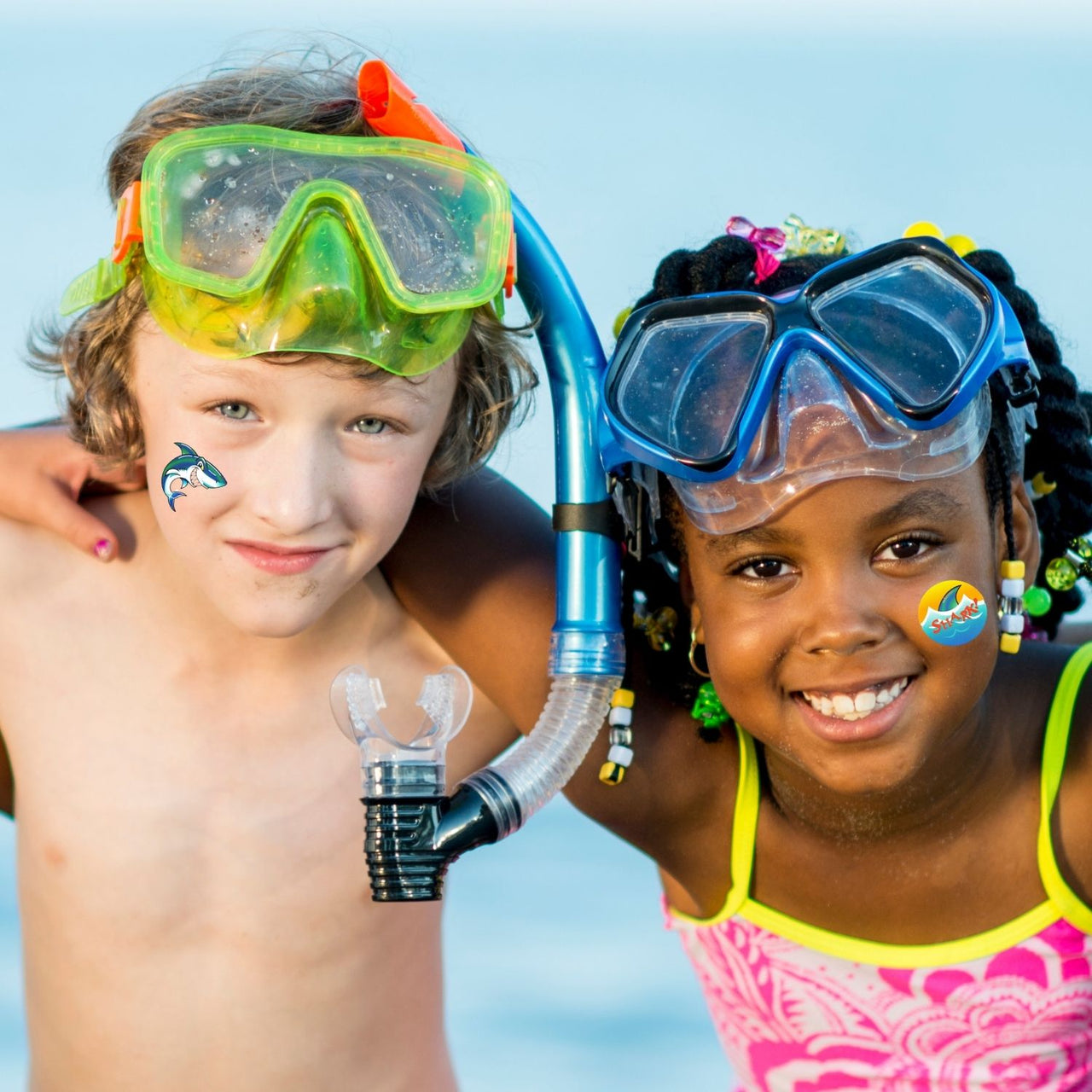 kids at the beach with washable shark tattoos smiling