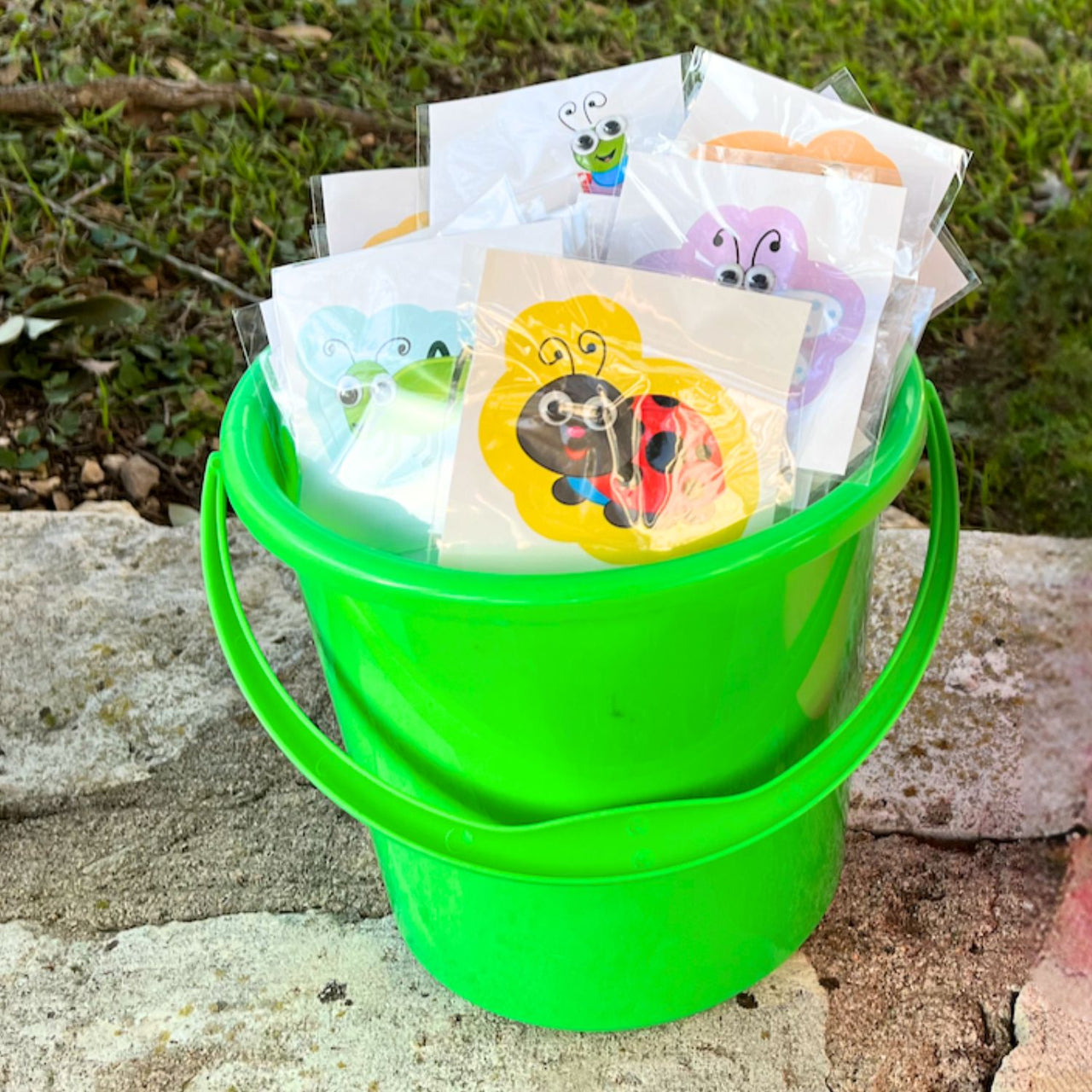 large bug stickers in a sand pail