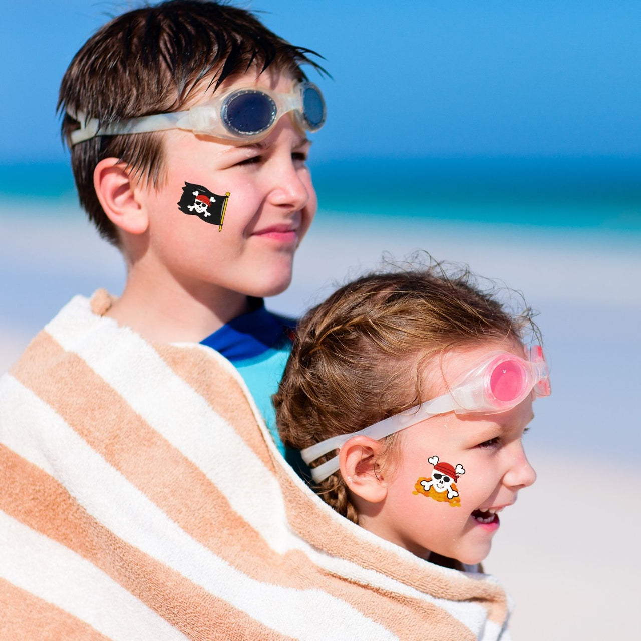 kids at beach with pirate removable tattoos on their cheeks