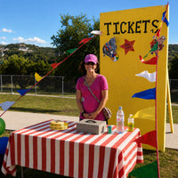 Thumbnail for ticket booth at a school with a smiling volunteer 